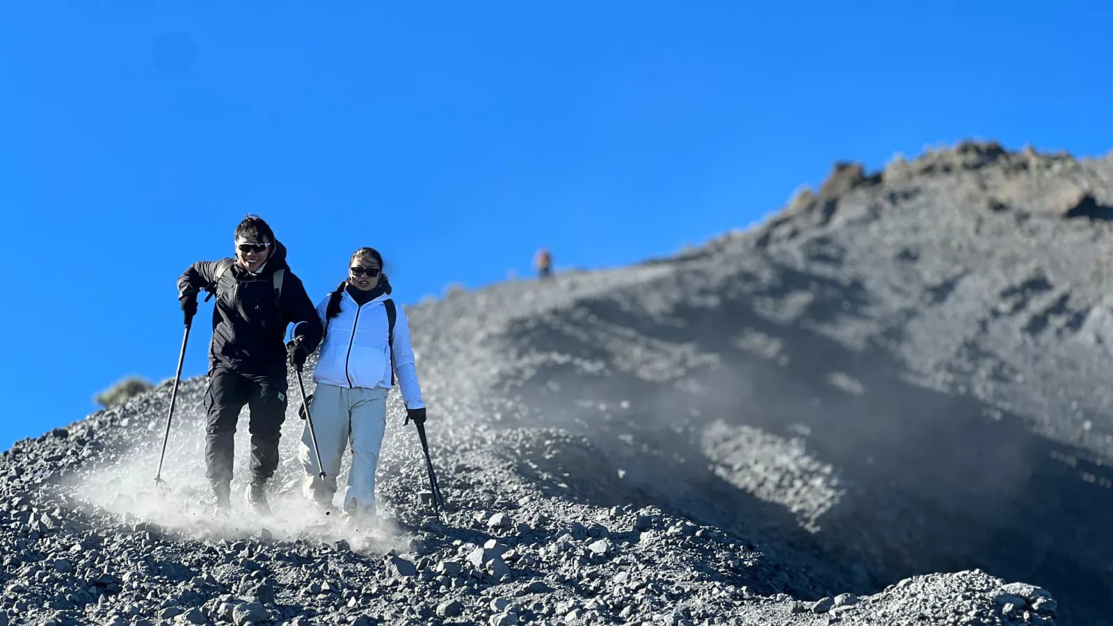 Dua pendaki menuruni jalur berbatu Gunung Rinjani